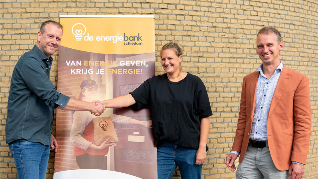 Yorick Haan en Krispijn Beek overhandigen namens GroenLinks 34 winddelen aan Evelijn van de Water van de Energiebank Schiedam