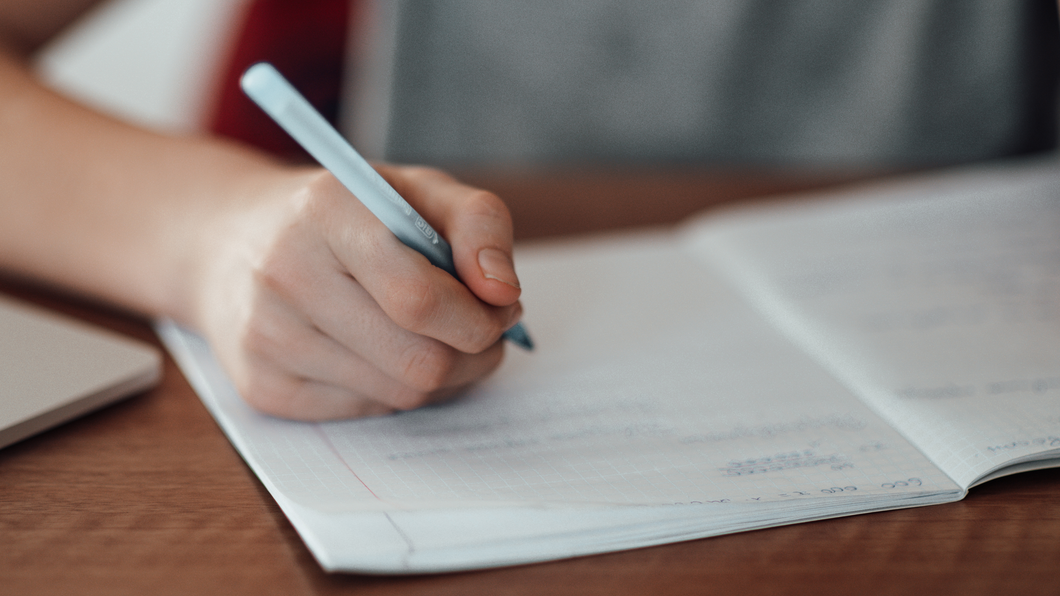 Kinderhand schrijft in wiskundeschrift