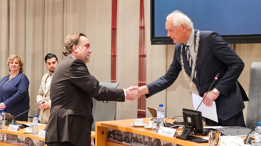 burgemeester Lamers feliciteert Menno na zijn installatie in de raad