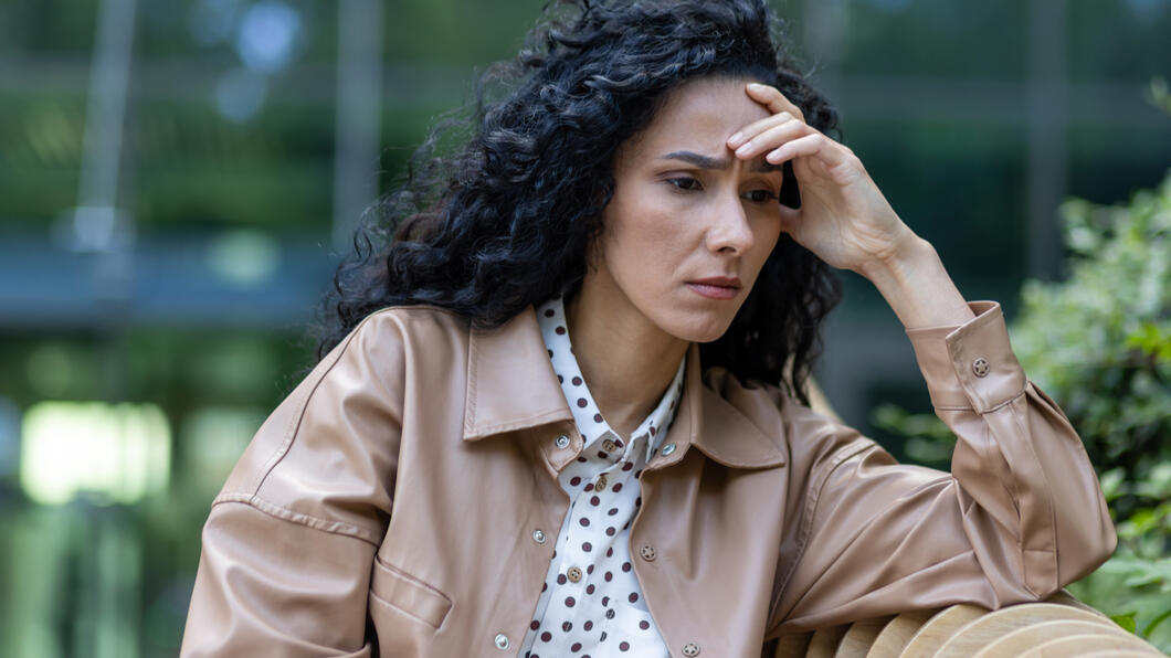 Gedeprimeerde vrouw zit te wachten op een bankje