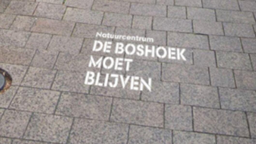 "De Boshoek moet blijven" staat met krijt op de stoep gespoten