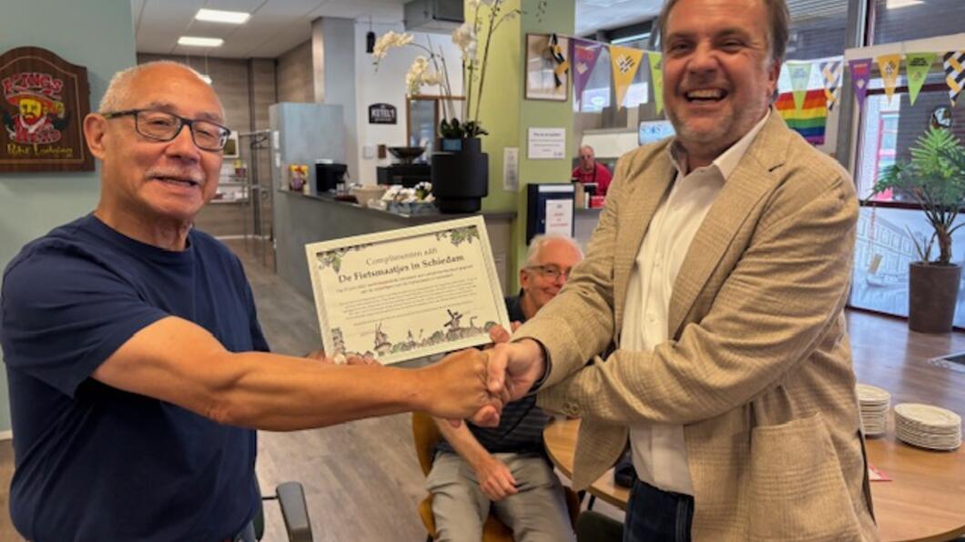 Menno Siljee overhandigt het complimentencertificaat aan Rob Kent van Fietsmaatjes Schiedam