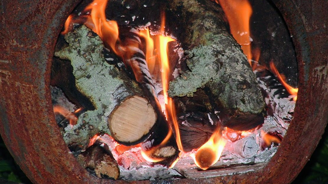 Brandende stukken hout in een buitenkachel