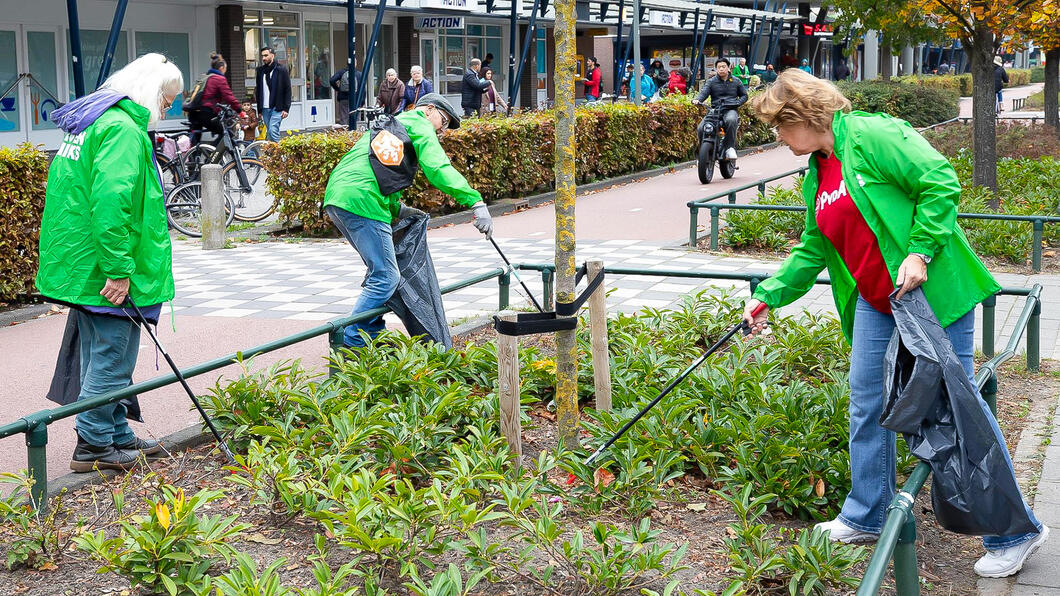 Campagnevoerders prikken vuil in een plantsoen aan de Nolenslaan