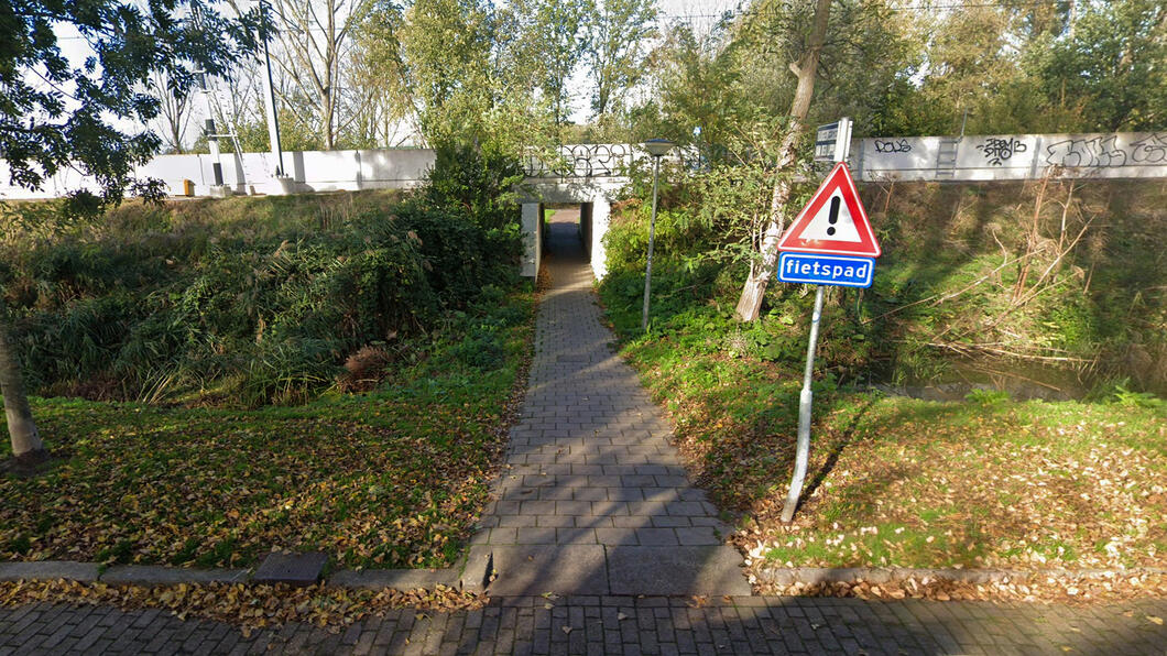 Donker en smal tunneltje onder het spoor door in de Staatsliedenbuurt