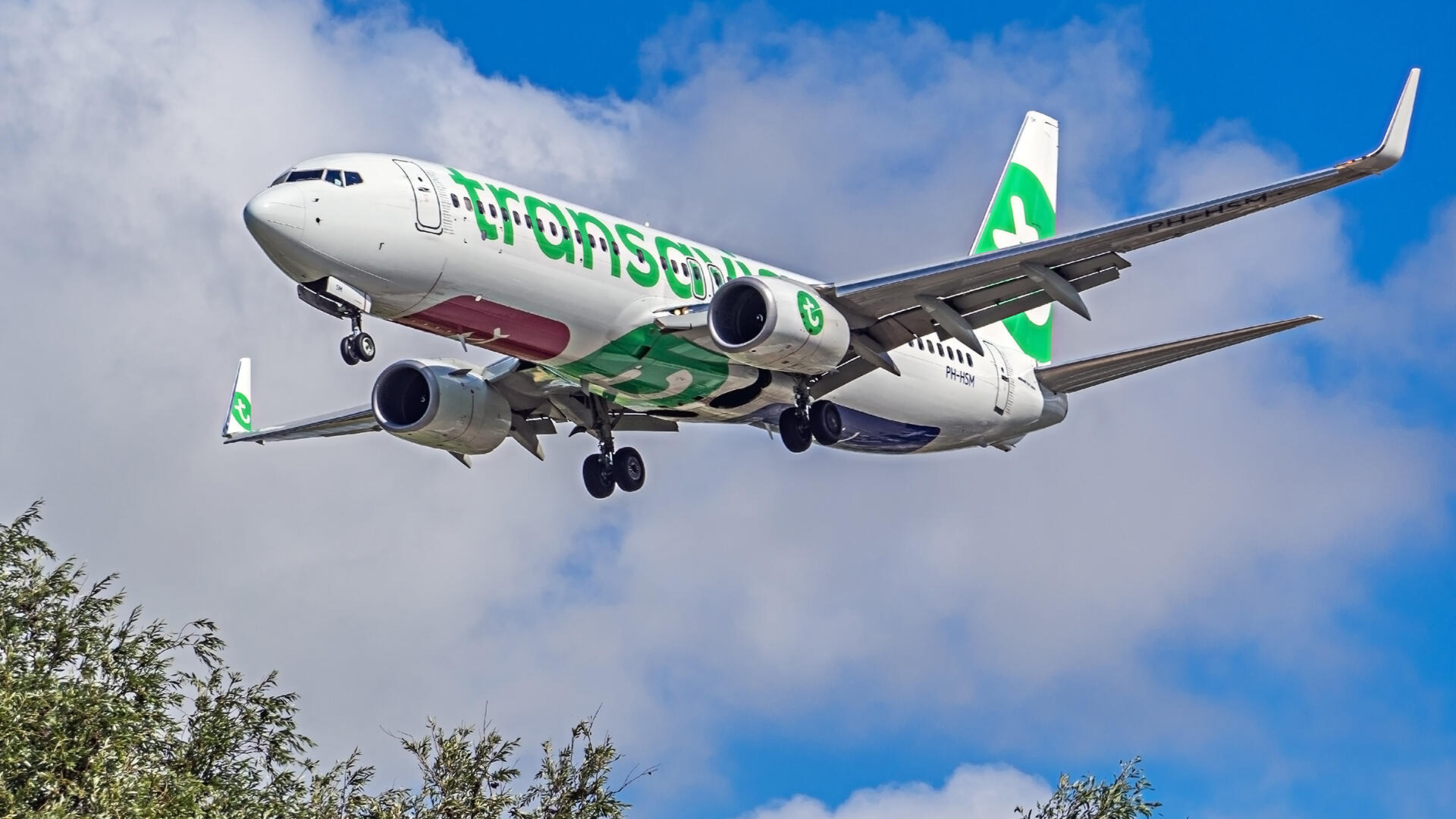 Een Transavia-vliegtuig vliegt laag over Schiedam