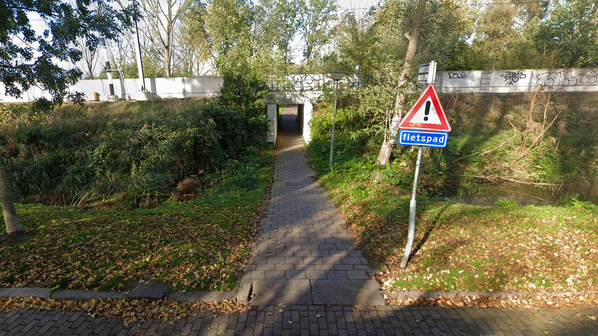 Donker en smal tunneltje onder het spoor door in de Staatsliedenbuurt